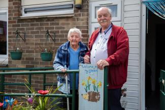 Older couple standing in their garden